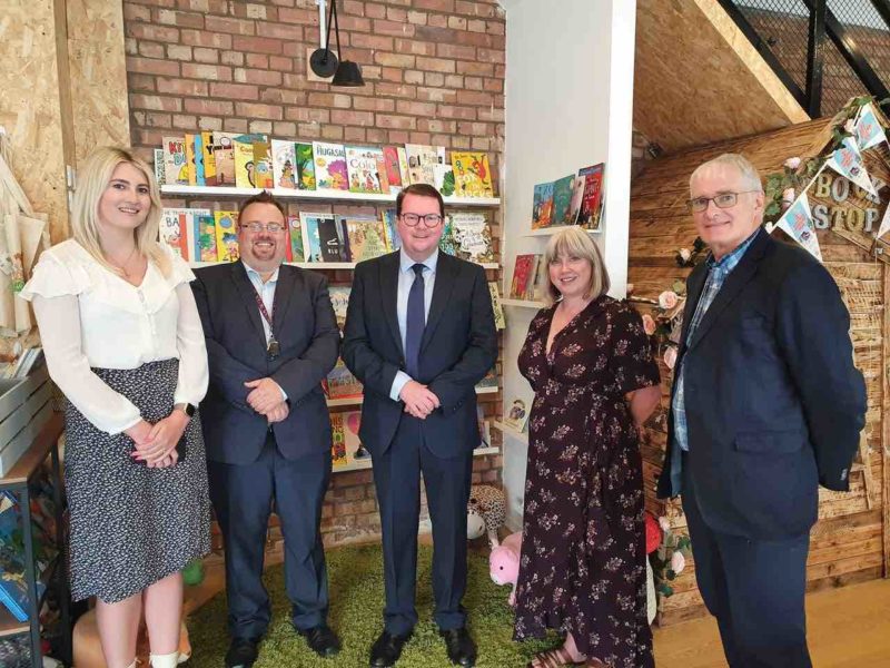 Conor McGinn stood with a small group of trustees in front of book shelves at St Helens